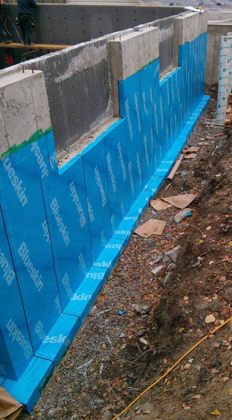 Self-adhered membrane installed along a stepped foundation wall