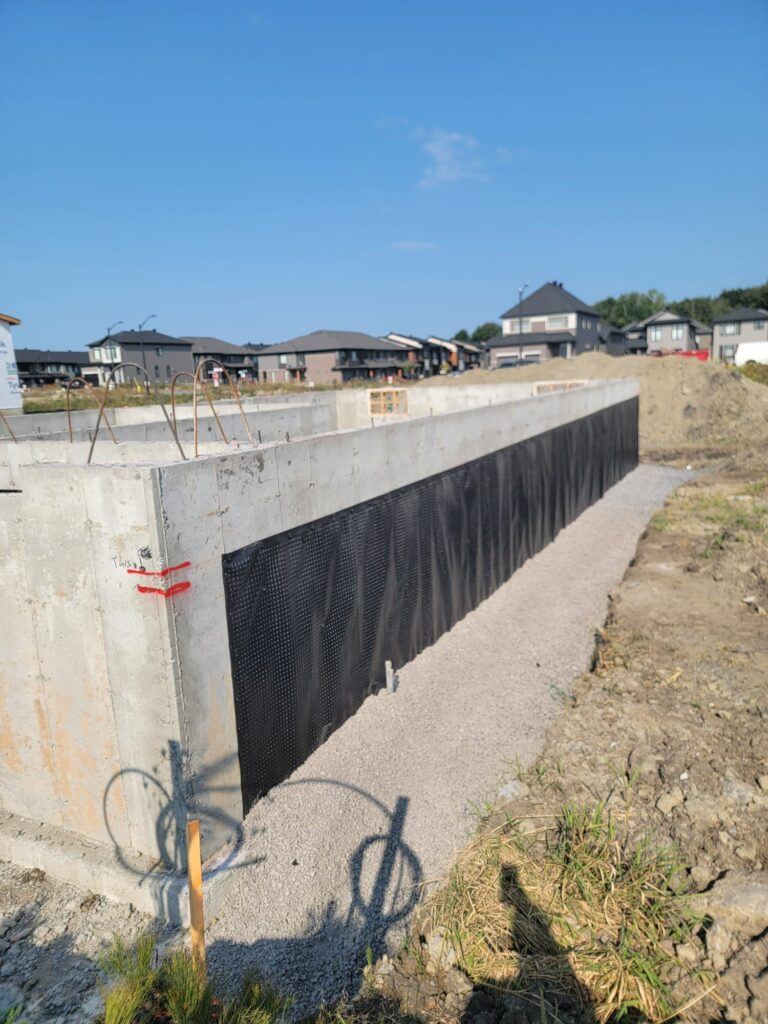 Drainage membrane installed on a long foundation wall in a new subdivision