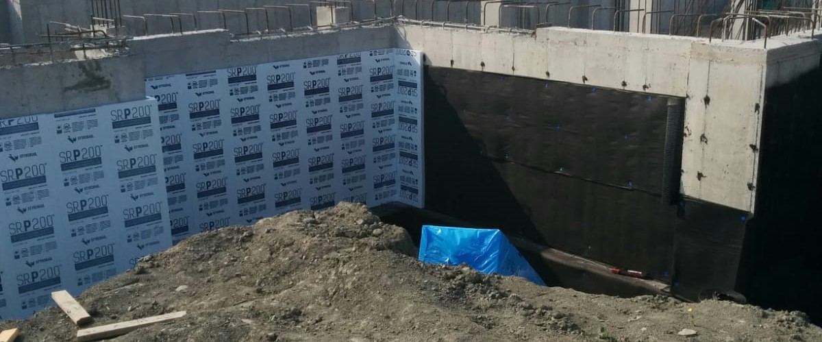 Insulation boards installed over waterproofing, with perimeter drain