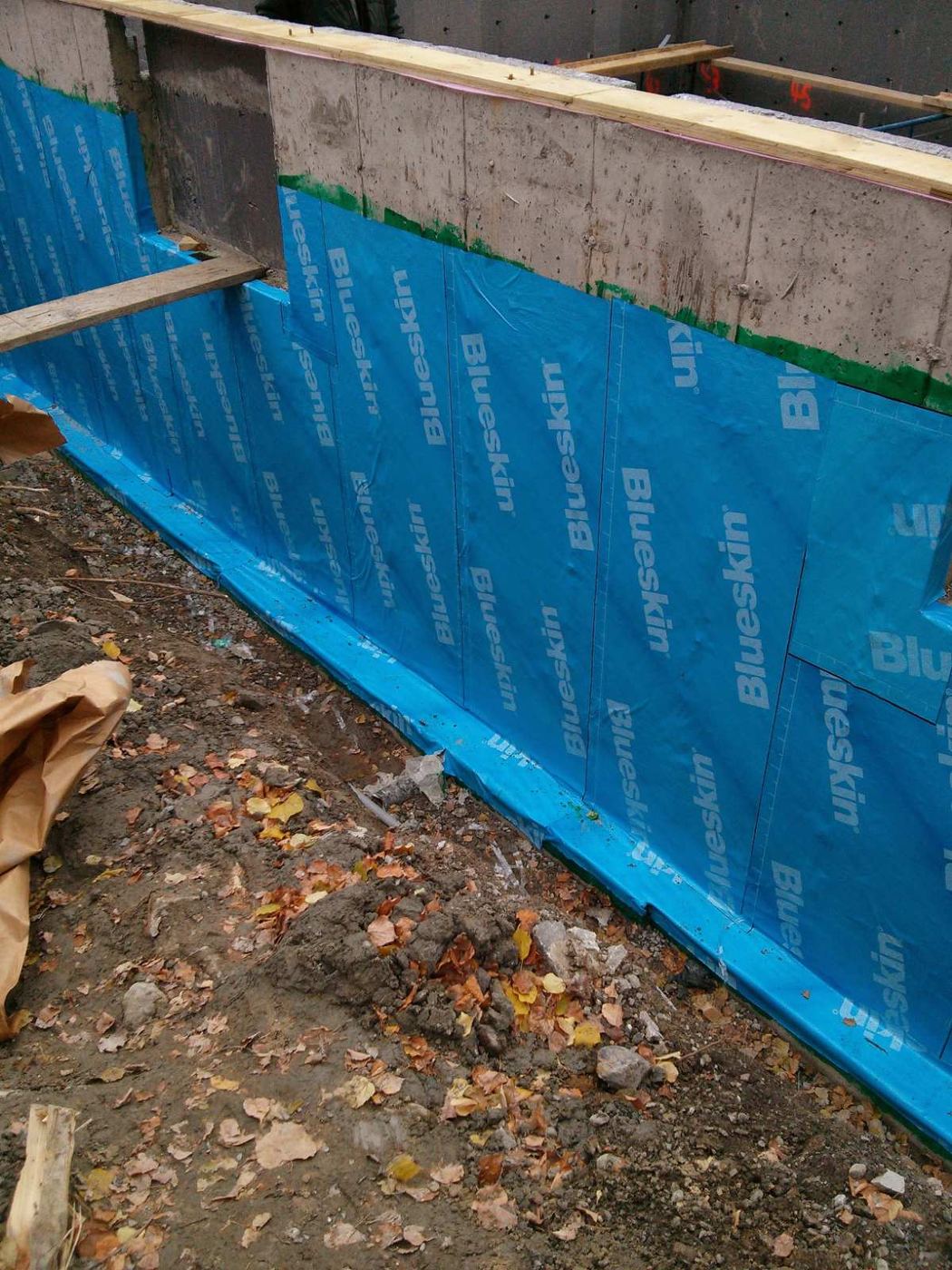 Self-adhered membrane on a foundation wall, ready for backfill