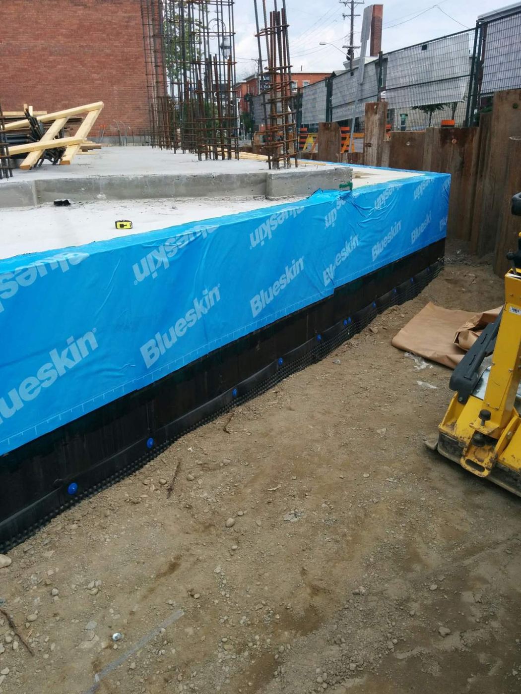Fastened drainage membrane with patched form-tie holes above
